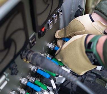 A military technician plugs in cables