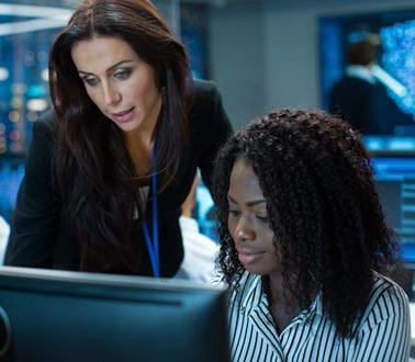 Two female consultants work at a computer