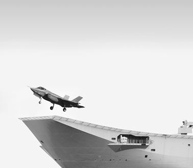 a fighter jet takes off from a warship