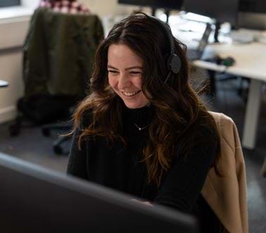 A female employee smiling at her desk