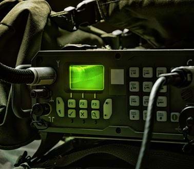 Wires plugged into military equipment with a green light